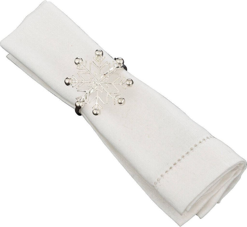 A white linen napkin folded and held by a snowflake-shaped napkin ring.