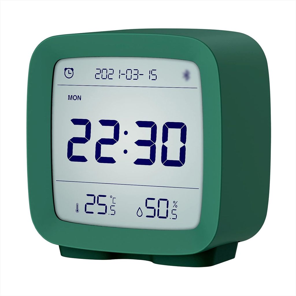A digital alarm clock displaying the time, date, temperature, and humidity.