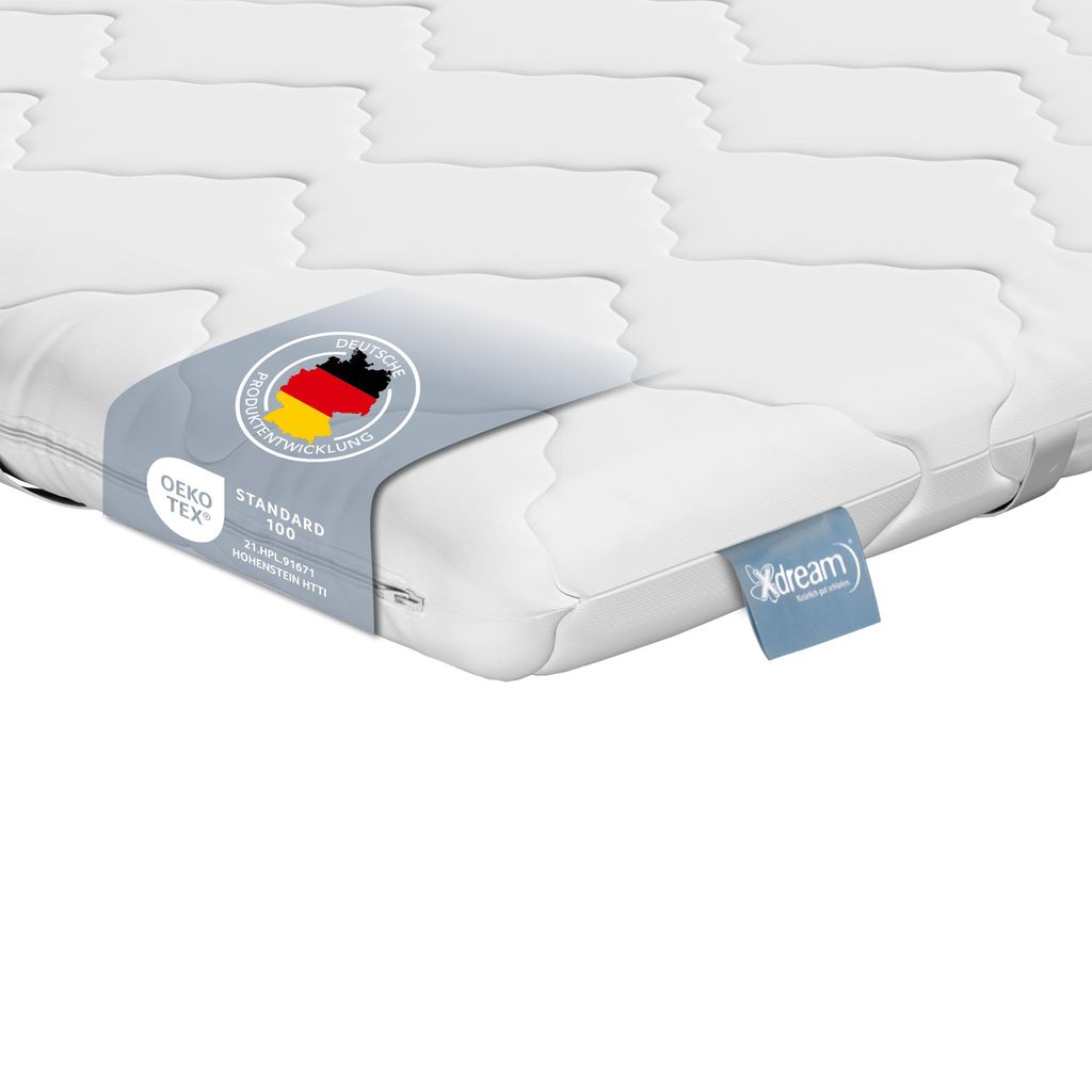 Close-up of a white mattress topper with labels.