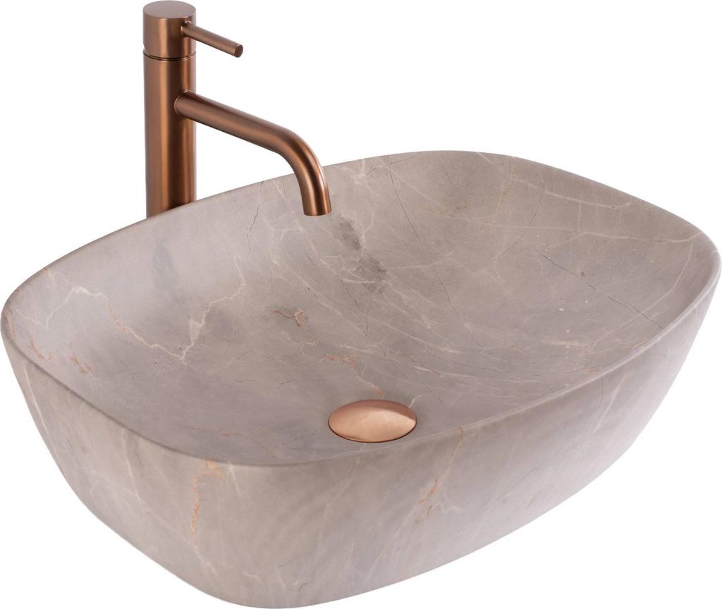 A beige marble vessel sink with a copper faucet and drain.