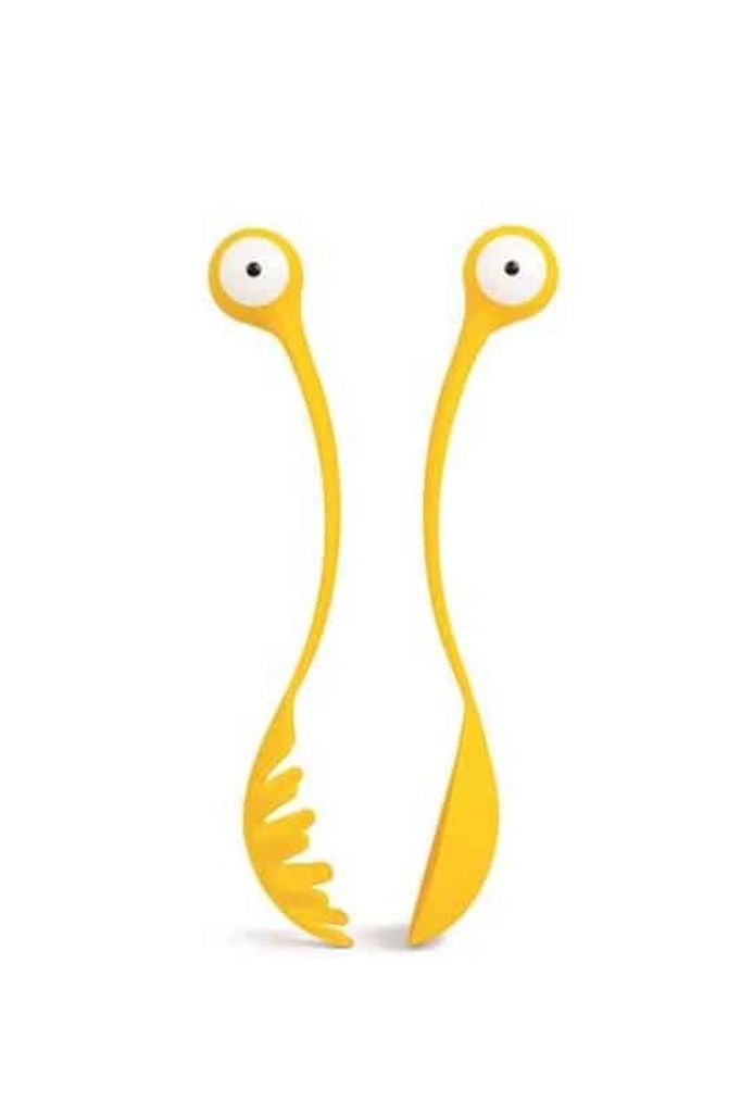 A pair of yellow pasta serving tongs with googly eyes, designed to look like a monster.