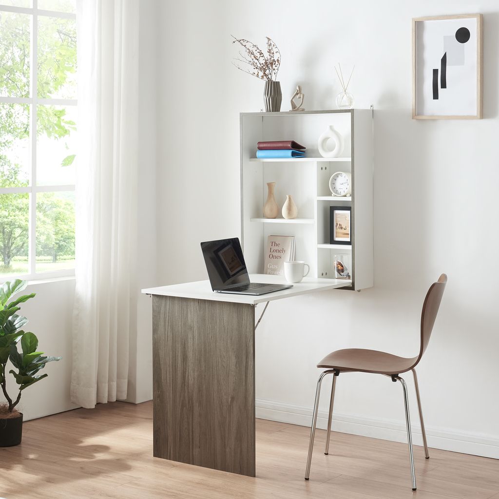 A wall-mounted folding desk with a shelf unit above it, shown in a room with a window and a chair.
