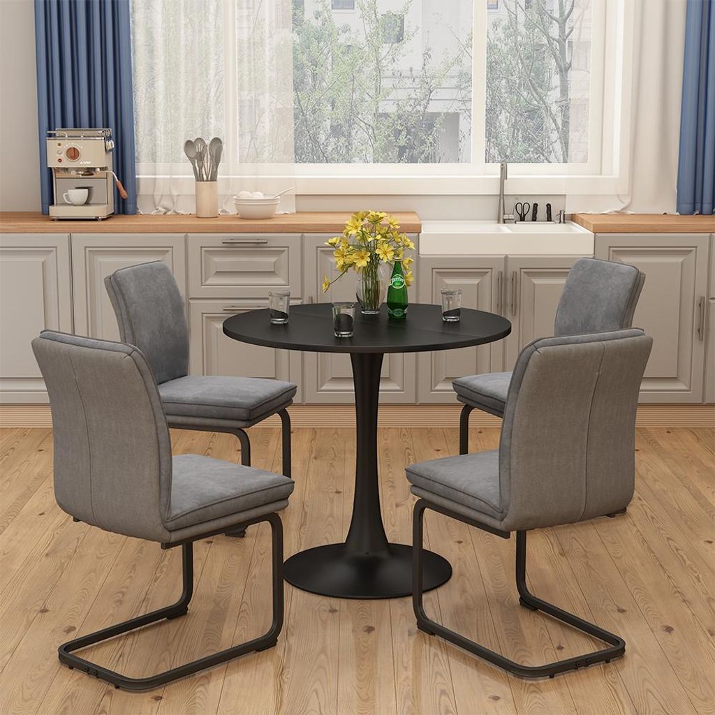 A dining set with a round table and four chairs in a kitchen setting.