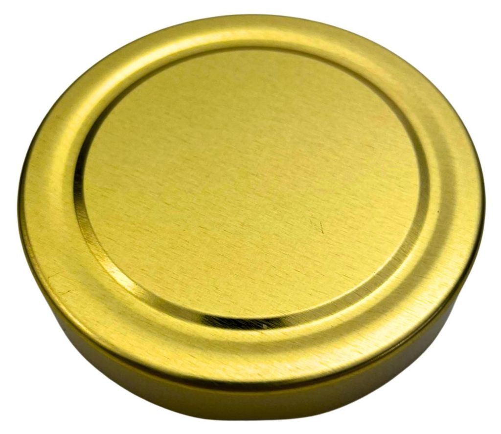 A close-up, top-down view of a single gold-colored jar lid.