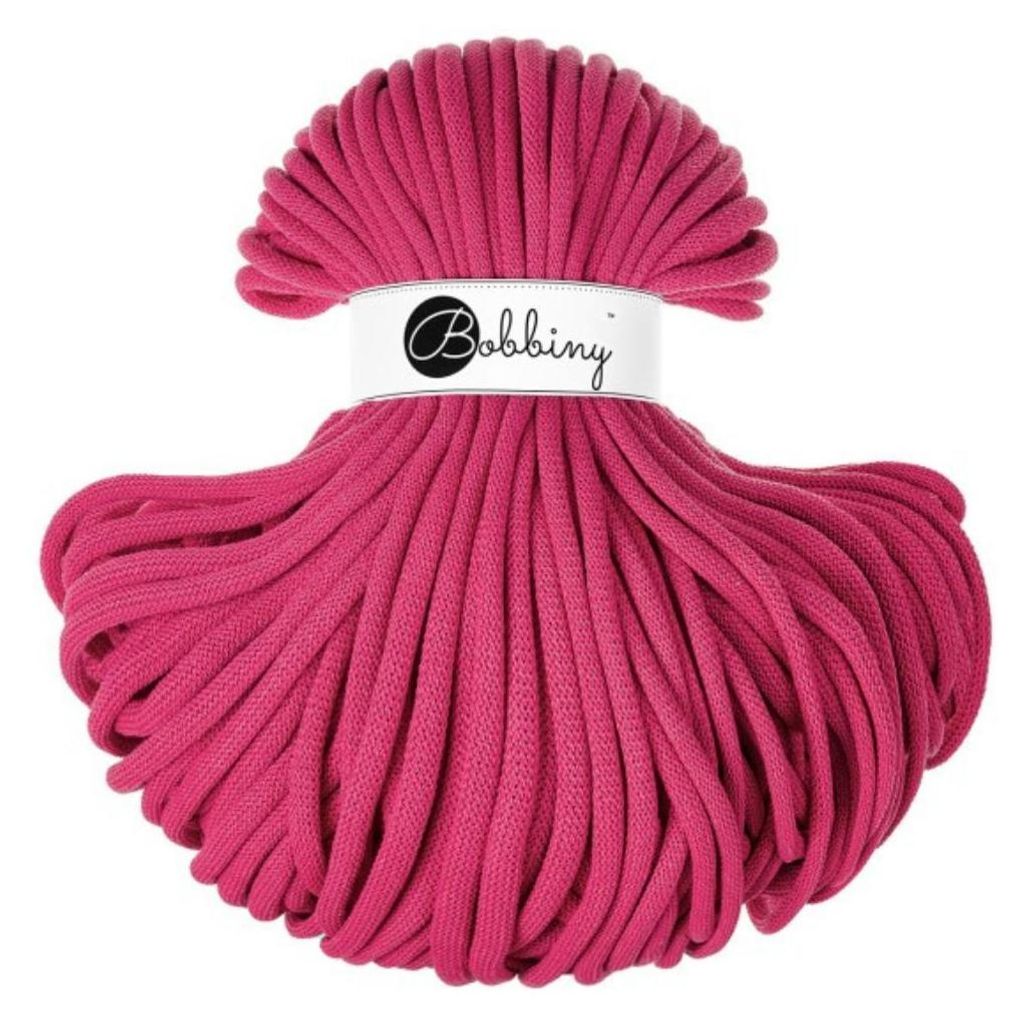 A spool of pink rope on a white background.