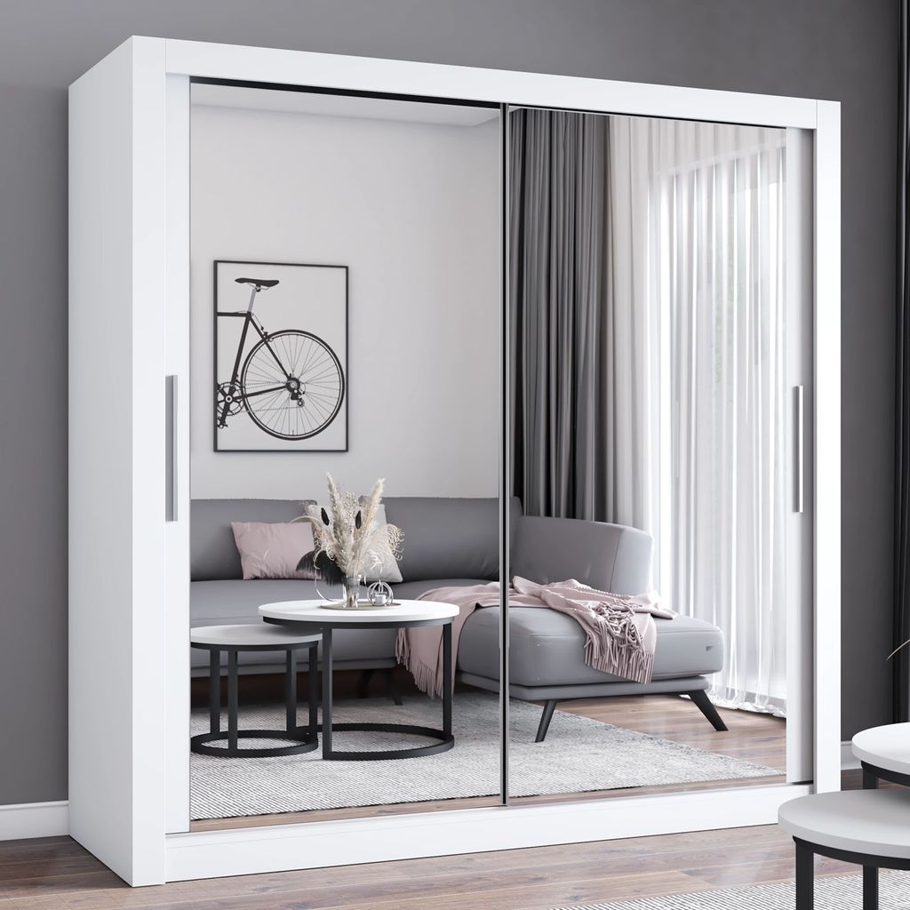 A modern living room with a sofa, coffee tables, and a large sliding door wardrobe with mirrored fronts.