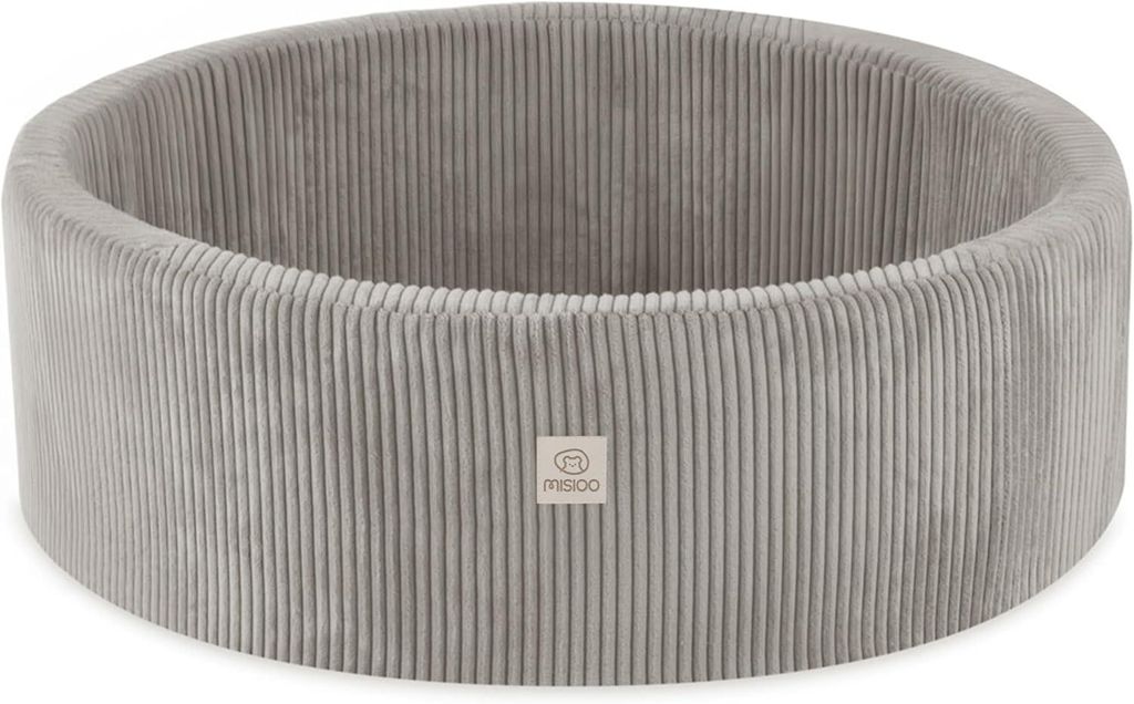 A round, beige corduroy ball pit with a small logo tag on the front.