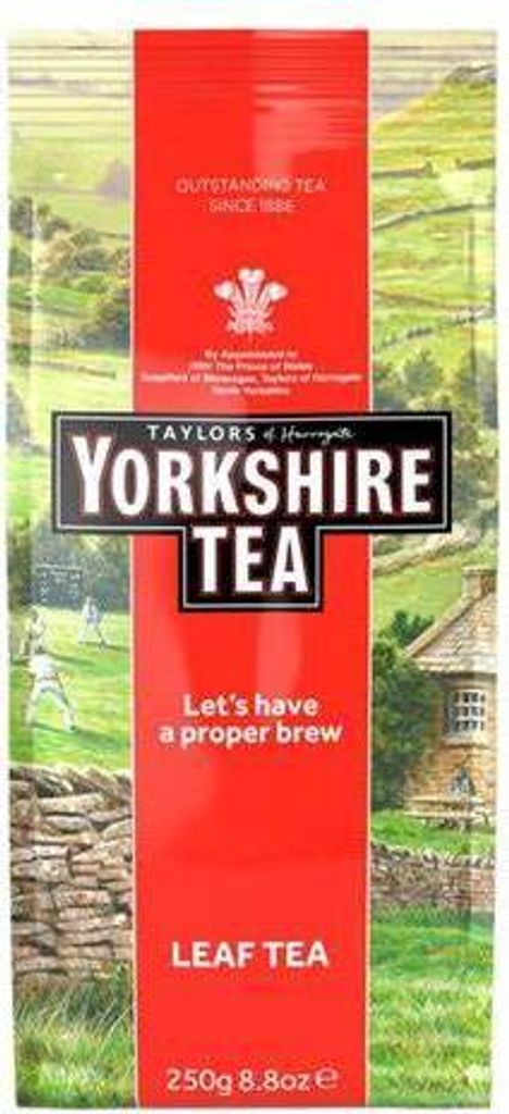 A bag of Yorkshire Tea with a rural landscape background.