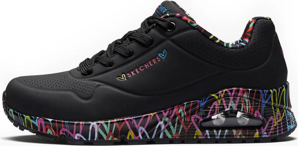 A side view of a black Skechers sneaker with a colorful heart pattern on the sole and heel.