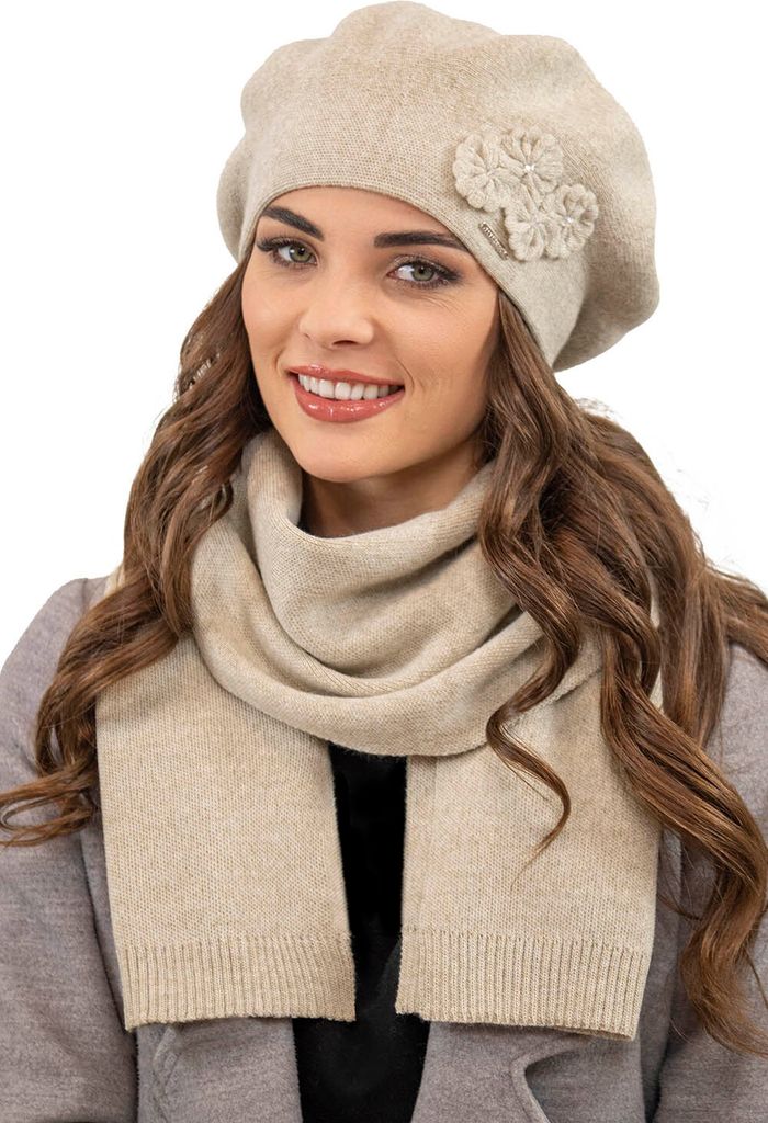 A woman wearing a beige beret and scarf.