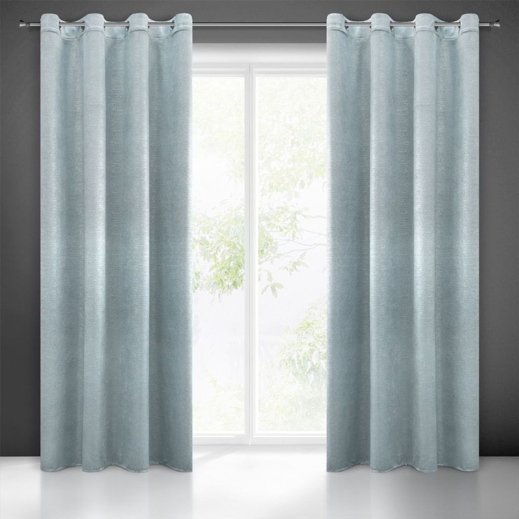 Two blue curtains hanging on a window rod in front of a window with trees visible outside.
