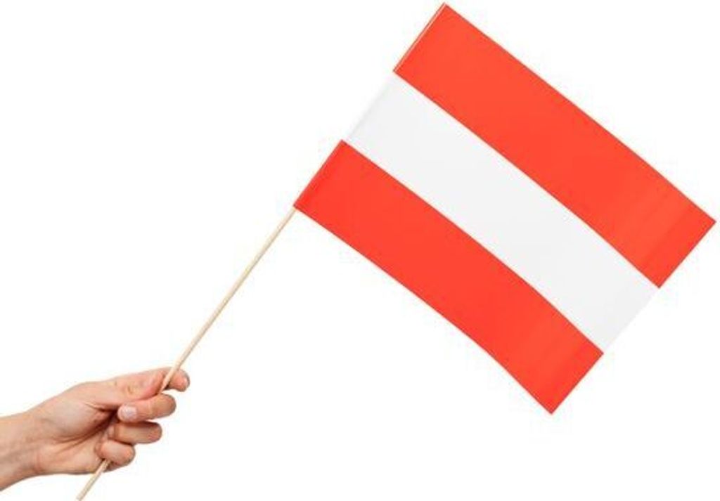 A hand holding a small Austrian flag on a white background.