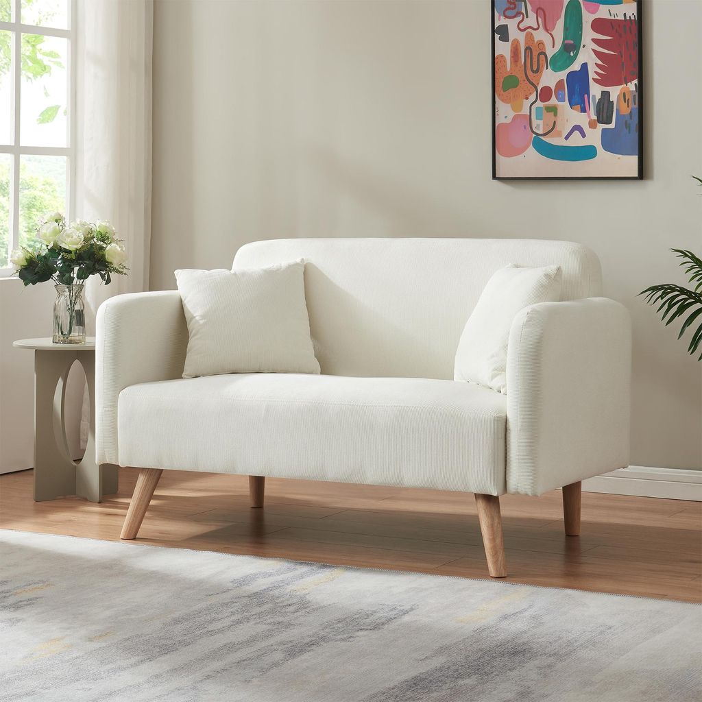 A living room scene with a sofa, side table, and artwork.