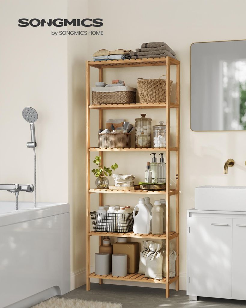 A tall, multi-tiered bamboo shelf unit filled with various bathroom items, positioned next to a bathtub and a vanity in a well-lit bathroom.