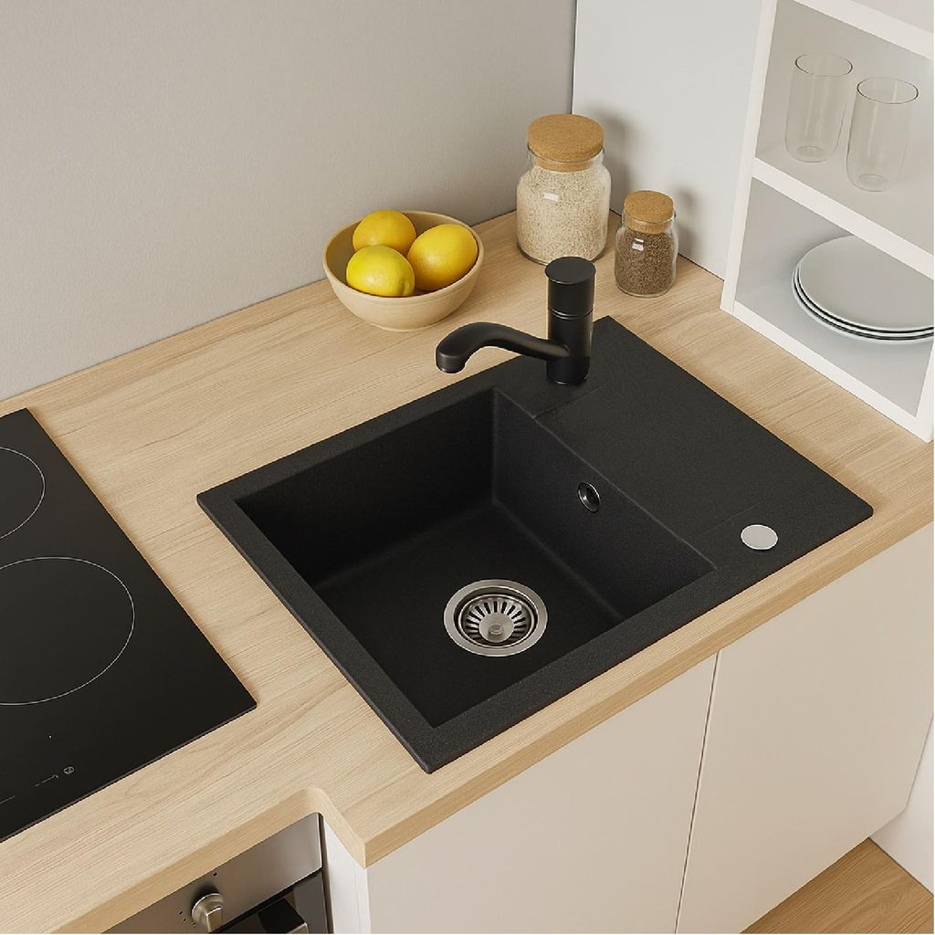 A modern kitchen sink area with a black sink, faucet, and countertop, next to a stovetop and a shelf with kitchen items.