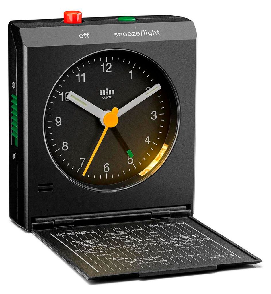 A black Braun alarm clock with its cover open, revealing a detailed chart inside.