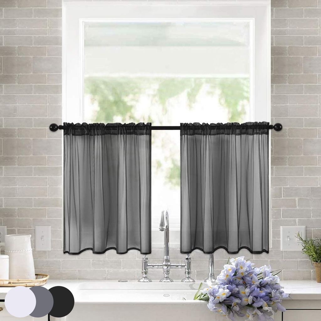 A kitchen sink area with black sheer bistro curtains hanging over the window.