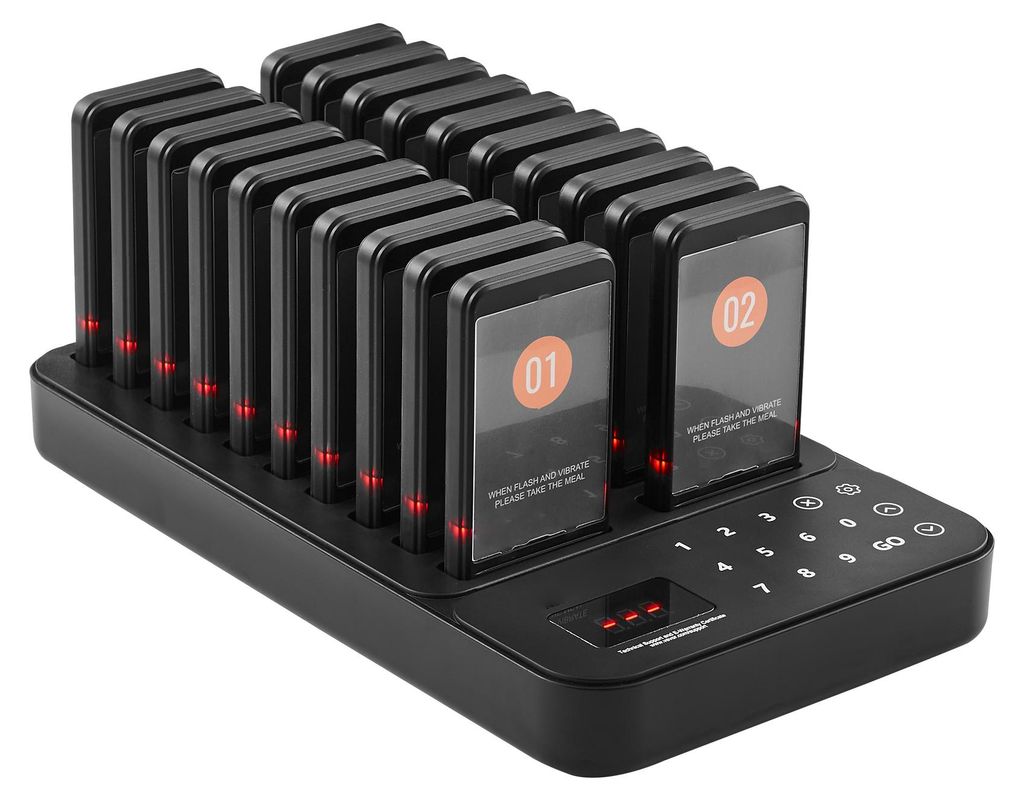 A black charging base with multiple pagers docked in it, displaying numbers and text.