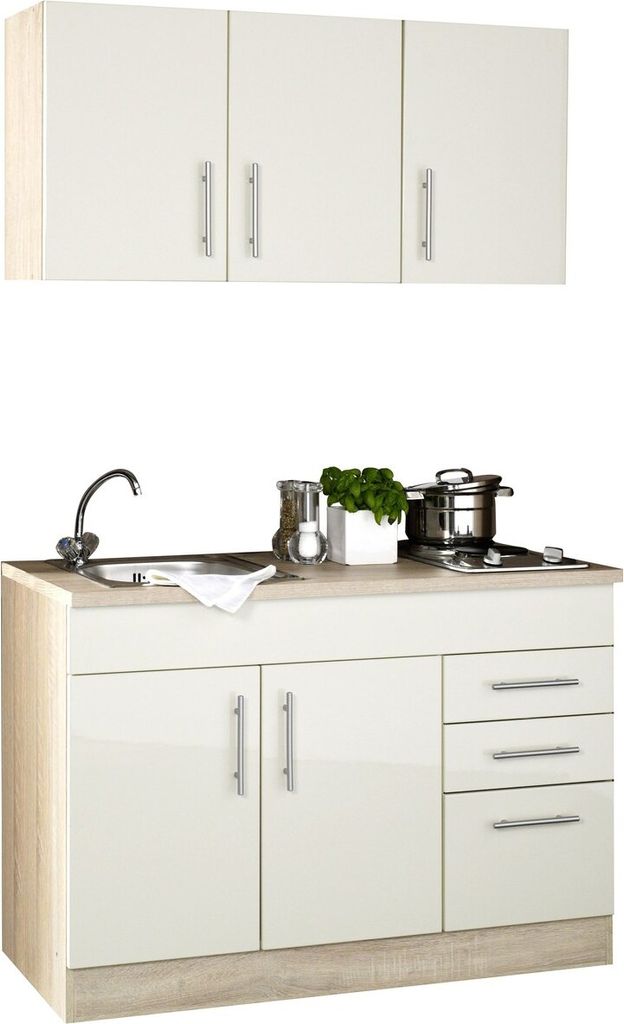 A white and beige kitchenette with a sink, stovetop, and cabinets.