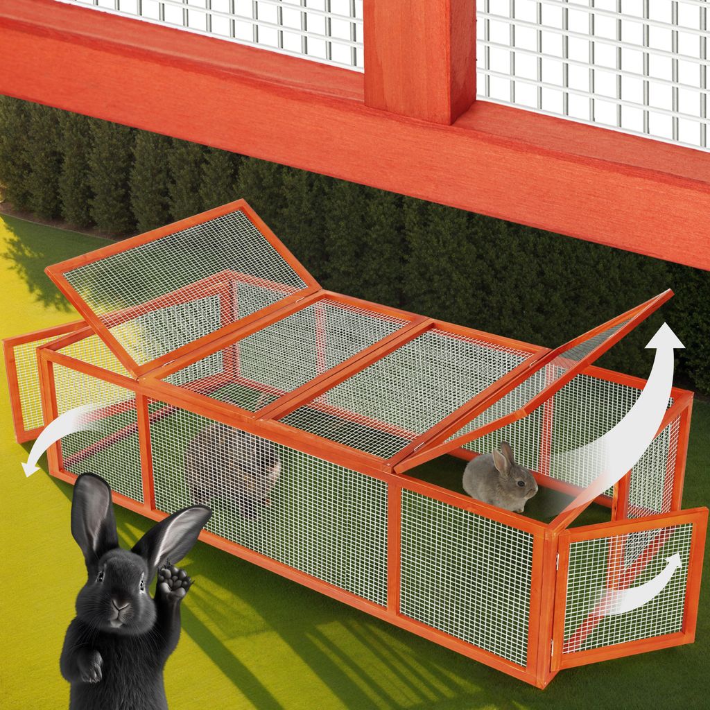A wooden rabbit hutch with open lids, set on a grassy lawn with a black rabbit in the foreground.