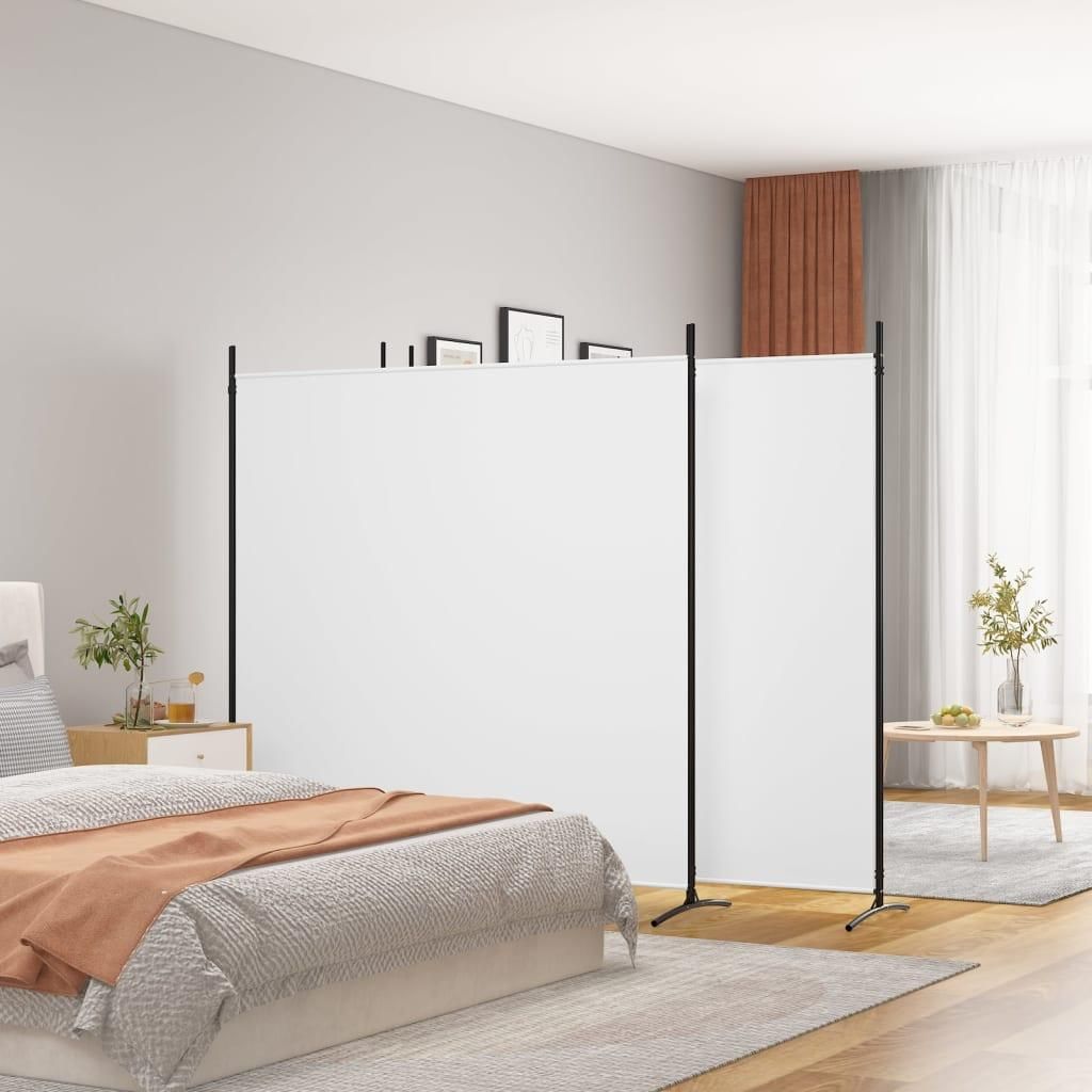 A bedroom scene with a white room divider separating the bed area from the rest of the room.