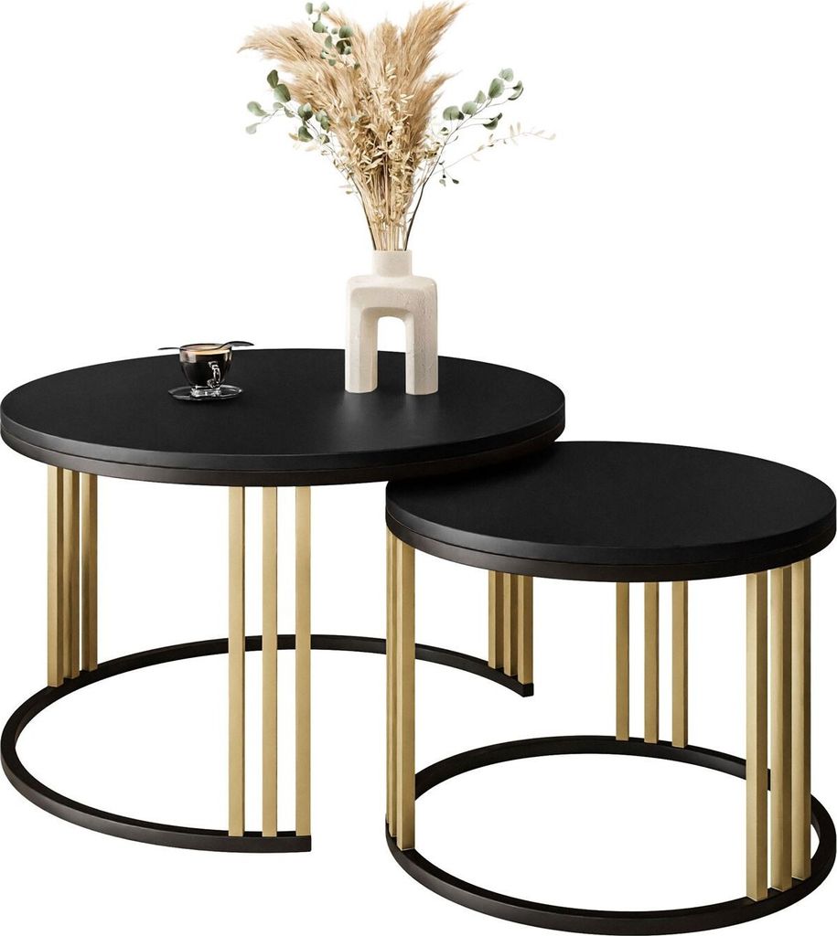 Two nesting coffee tables with black tops and gold legs, one with a vase and dried flowers on it.