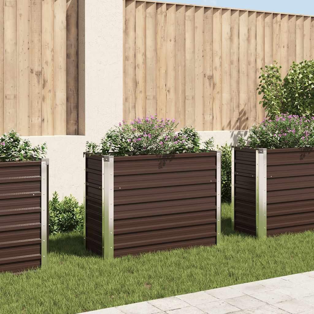 Three brown rectangular garden planters with silver trim are placed on a green lawn in front of a wooden fence and a white wall.