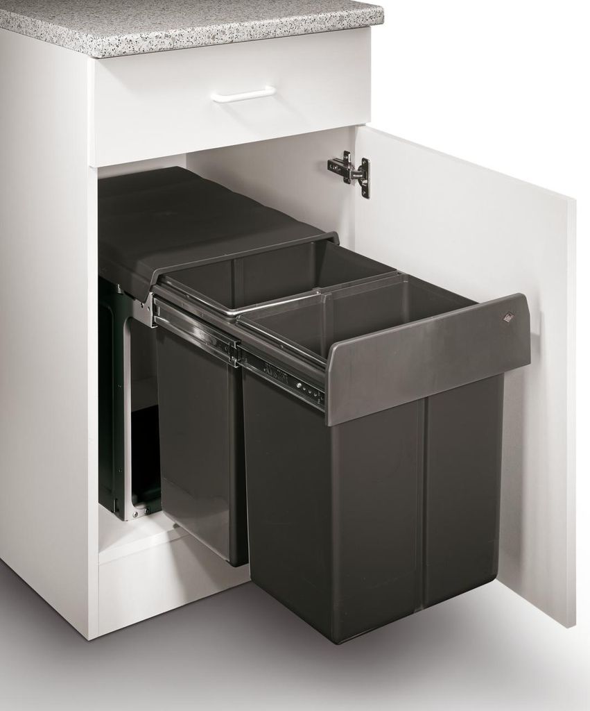 A pull-out trash bin system with two compartments installed in a kitchen cabinet.
