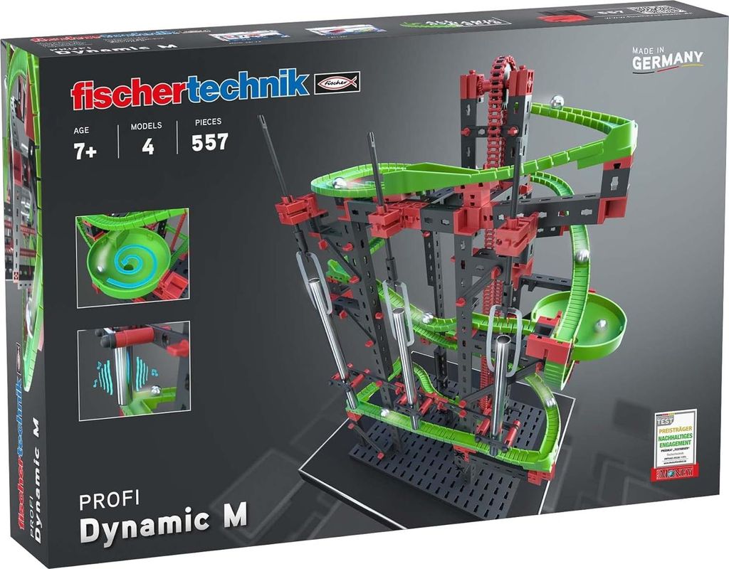 The image shows the packaging of a Fischertechnik building toy set, specifically the Dynamic M model. The packaging features a prominent image of the assembled toy, which is a marble run with various tracks and mechanisms. Information such as age recommend