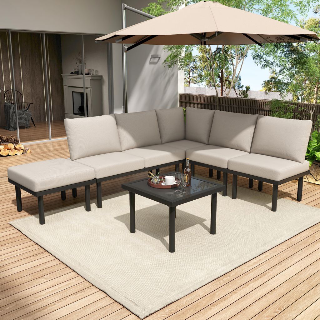 An outdoor patio scene with a sectional sofa, coffee table, and umbrella.