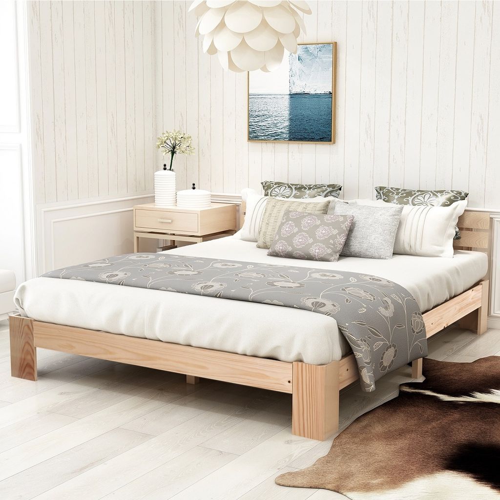 A bedroom scene with a wooden bed frame, bedding, and a nightstand.