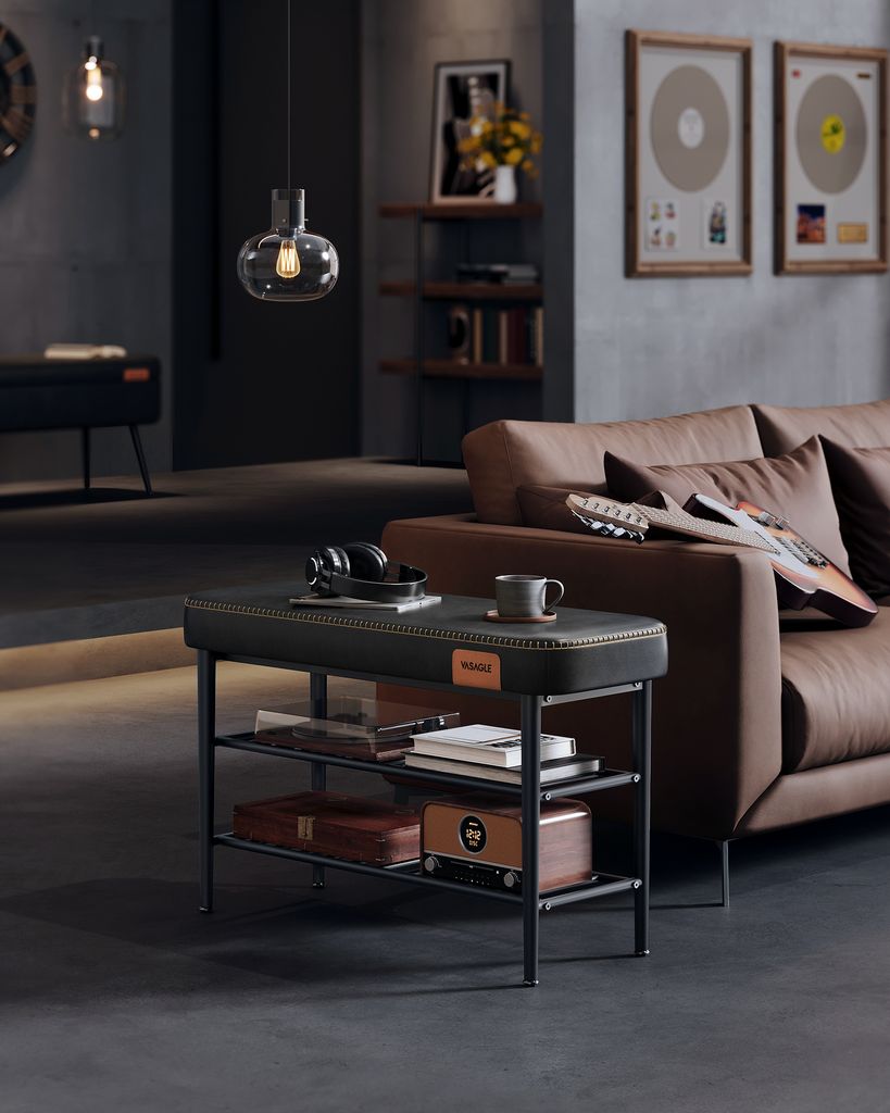 A modern living room with a brown sofa, shelves, and a black bench with storage.