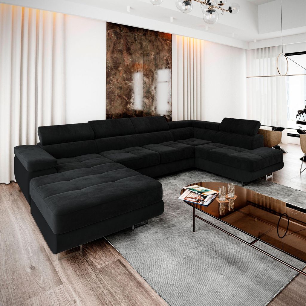 A modern living room scene with a large, black sectional sofa and a glass coffee table.