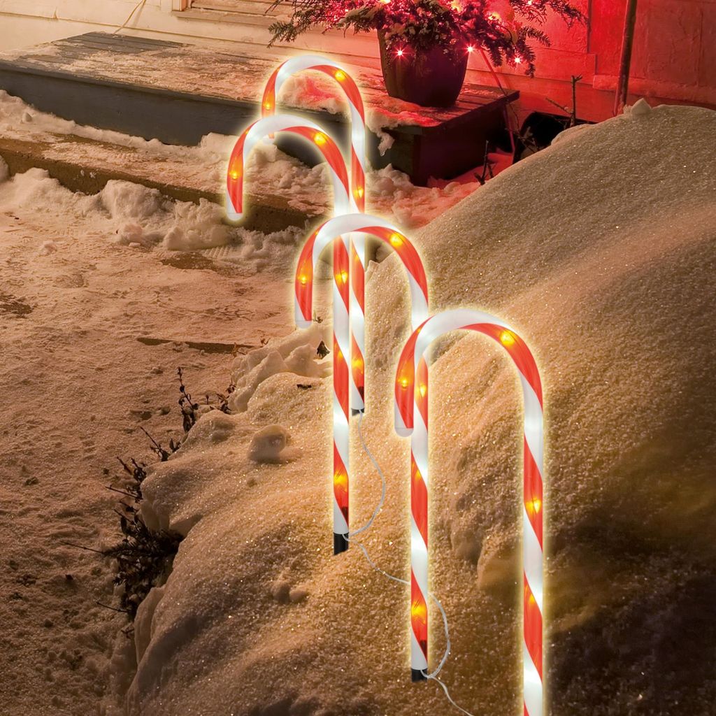 Candy canes with lights in the snow.