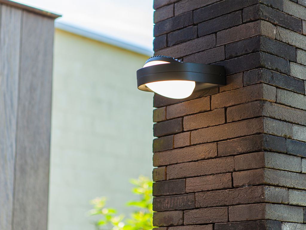 An outdoor wall light is mounted on a brick pillar.