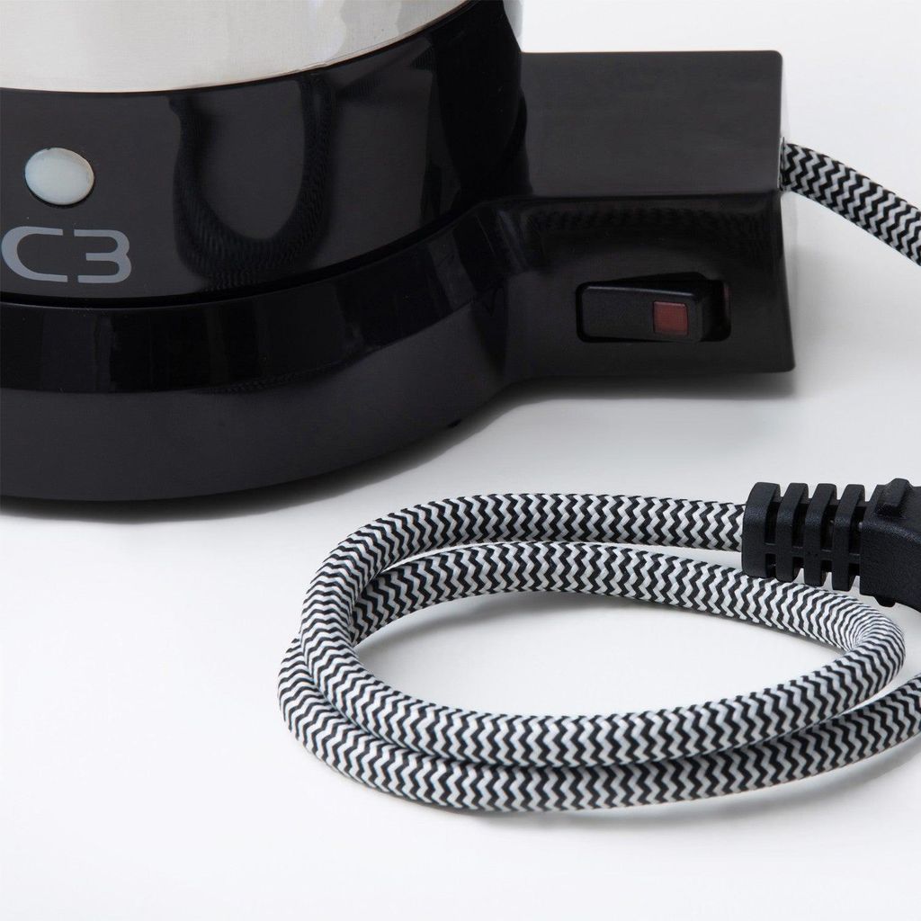 A close-up view of the base of a black coffee maker with a power cord coiled in the foreground.