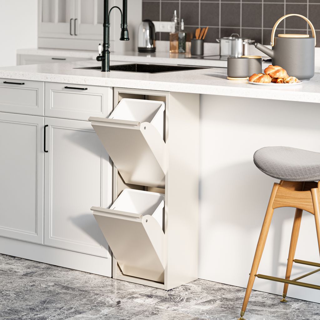A modern kitchen with white cabinets and a white countertop. A pull-out trash bin system with two compartments is visible, along with a black faucet and sink.