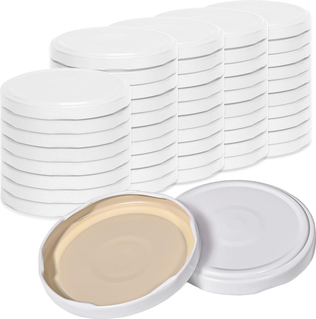 Stacks of white jar lids are arranged in rows, with two lids in the foreground showing the inside.