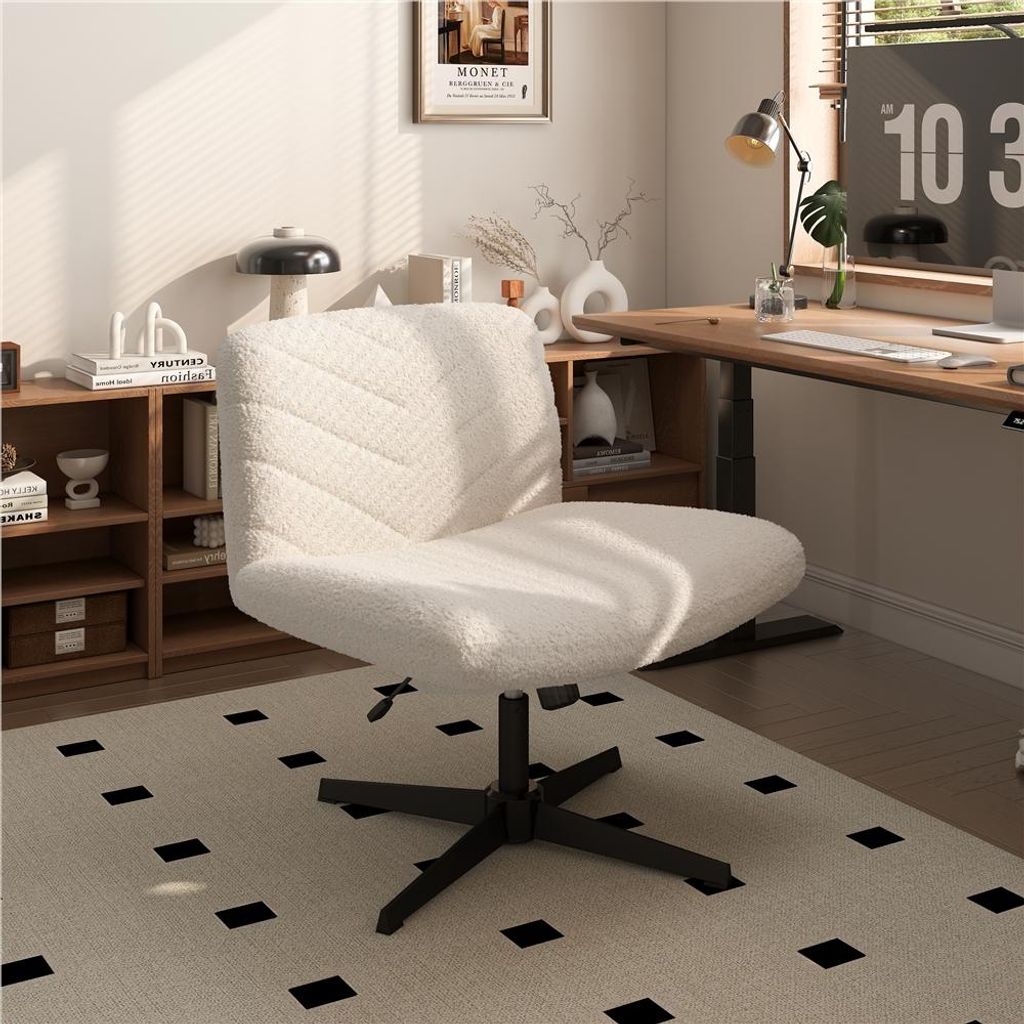 A white fluffy office chair is placed in a home office setting with a wooden desk and shelves.