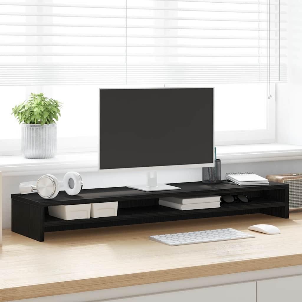 A monitor stand on a desk in front of a window with blinds.