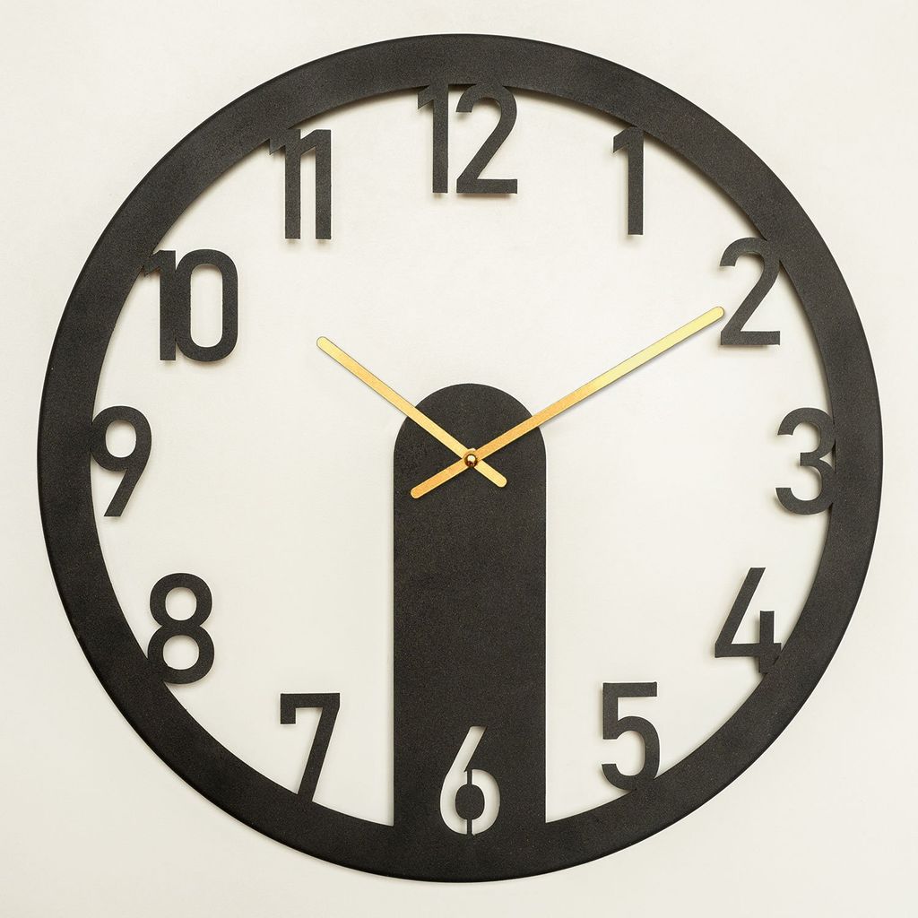 A black wall clock with gold hands against a white background.