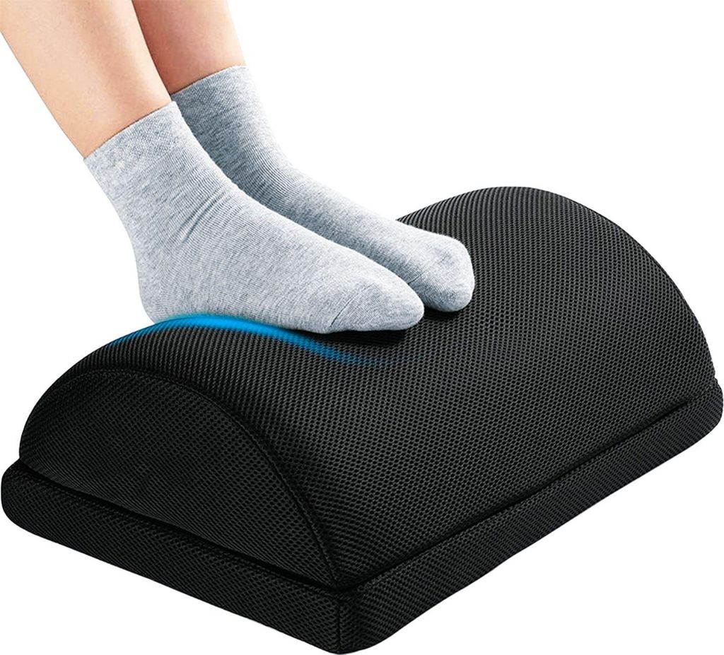 A pair of feet wearing gray socks rests on a black footrest.