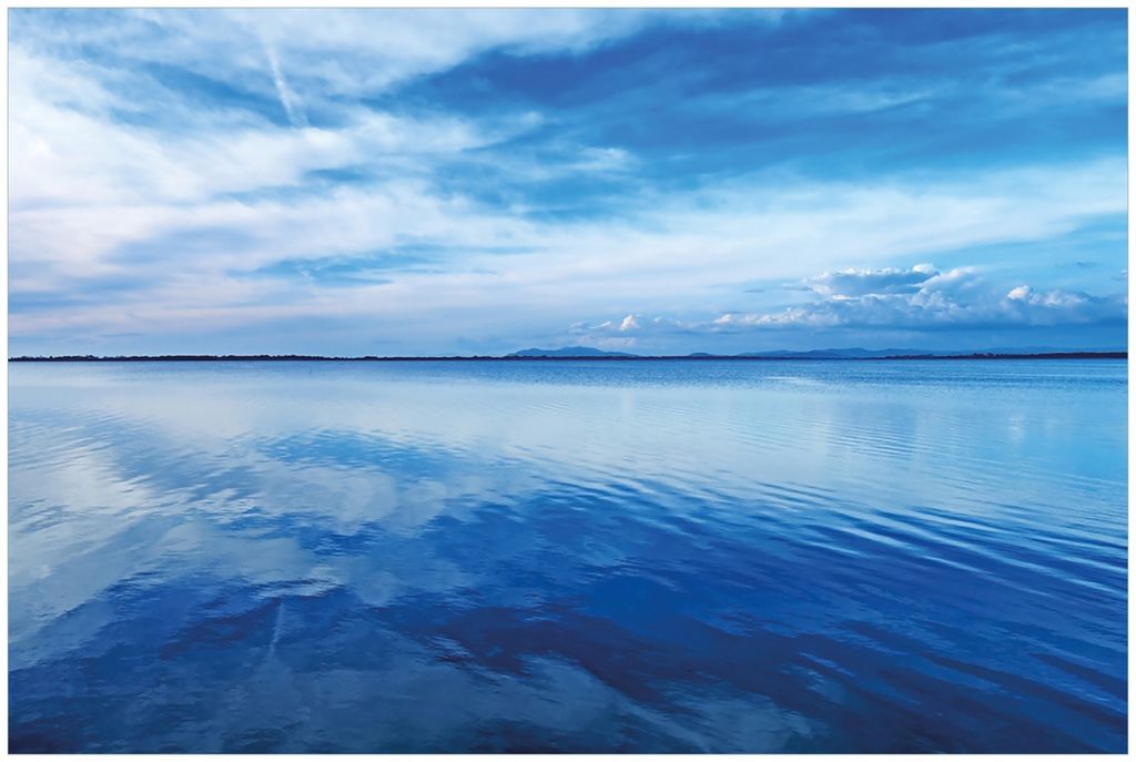 Wallario Premium Glasbild, freischwebende Optik, kräftige Farben, Größe 90 x 60 cm Motiv Blaue Meeresbucht in Italien mit Spiegelung im Wasser