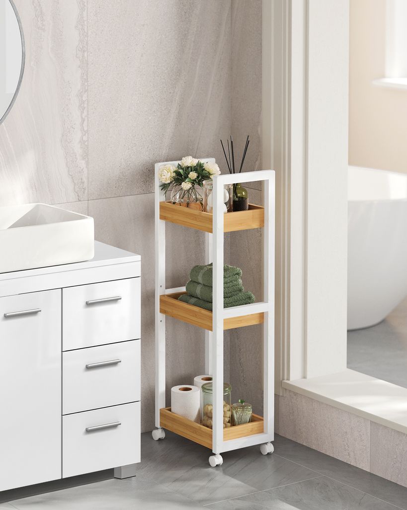 A white and wood-colored rolling storage cart in a bathroom next to a vanity.