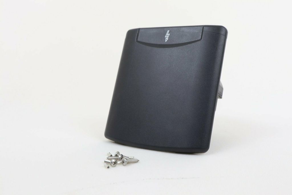 A black electrical socket with a lightning bolt symbol on a white background, with some metal screws in the foreground.
