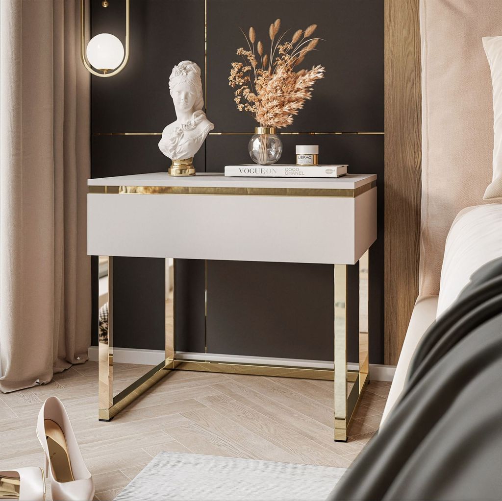 A modern bedroom setting with a nightstand, decor, and a bed.