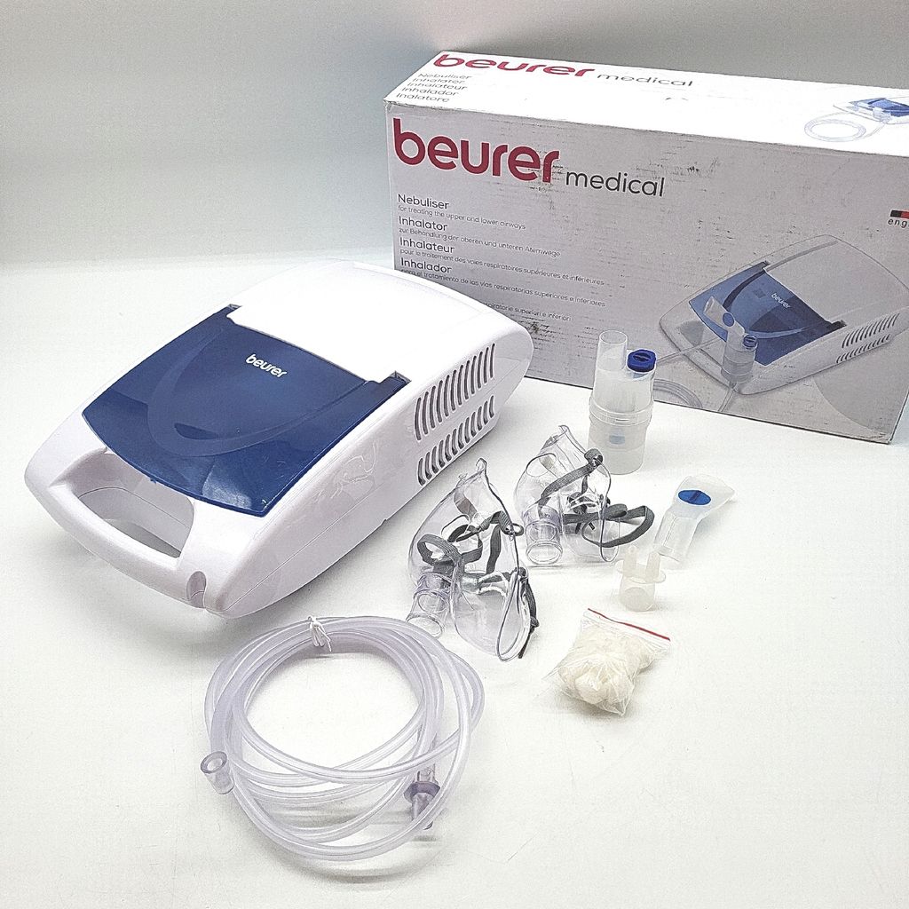 A Beurer medical inhalator and its accessories are displayed on a white surface, with the product's packaging in the background.