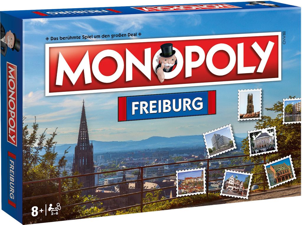 The image shows the front of a Monopoly board game box for the city of Freiburg. The box features a cityscape with a prominent church tower and several small stamp-like images of buildings.