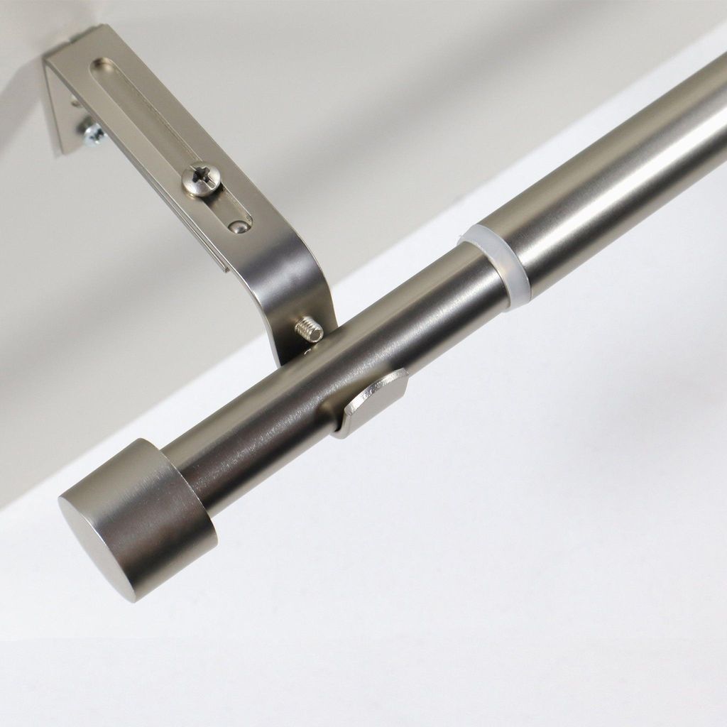 Close-up view of a metal curtain rod with a bracket and end cap.