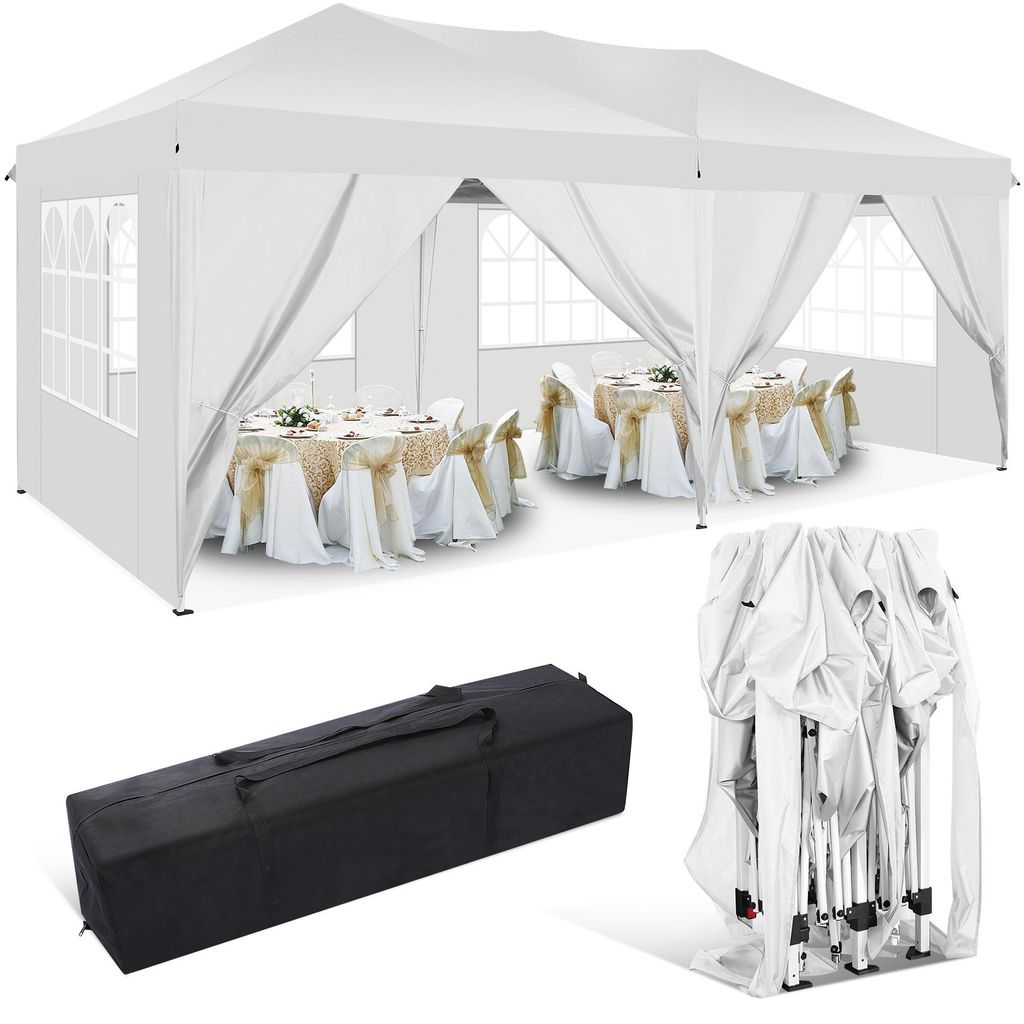 A white party tent set up with tables and chairs inside, along with a folded tent and a carrying bag.